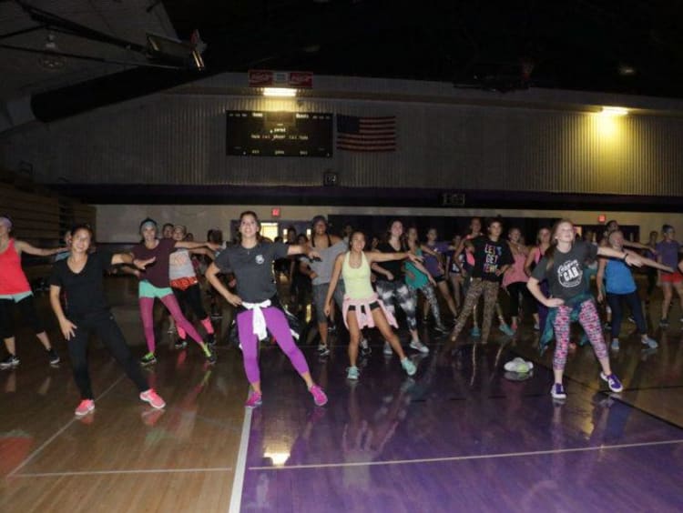 A group of students doing Zumba in a campus gym