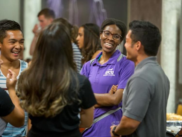 Woman in GCU shirt talking to students