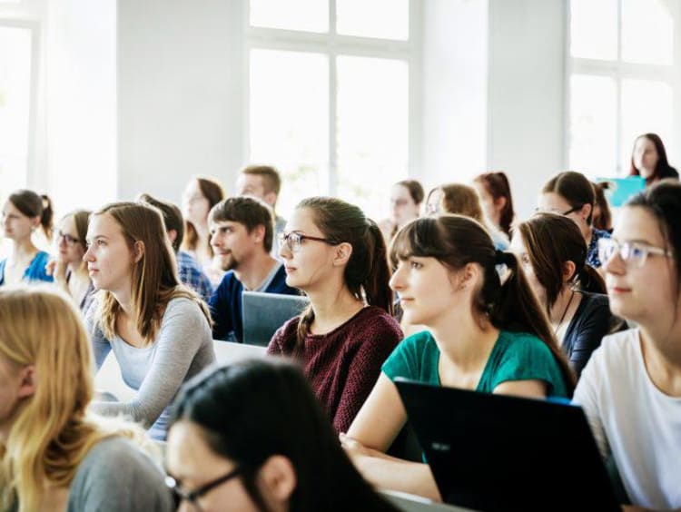 University Students Listening And Concentrating During Lecture