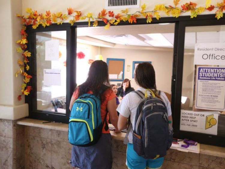 two students at an office window