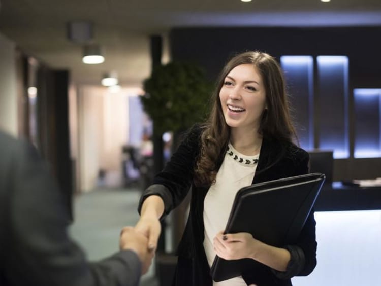 girl shaking someones hand and smiling