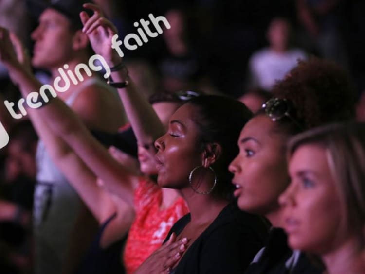 GCU students worshiping at Chapel under the Trending Faith logo