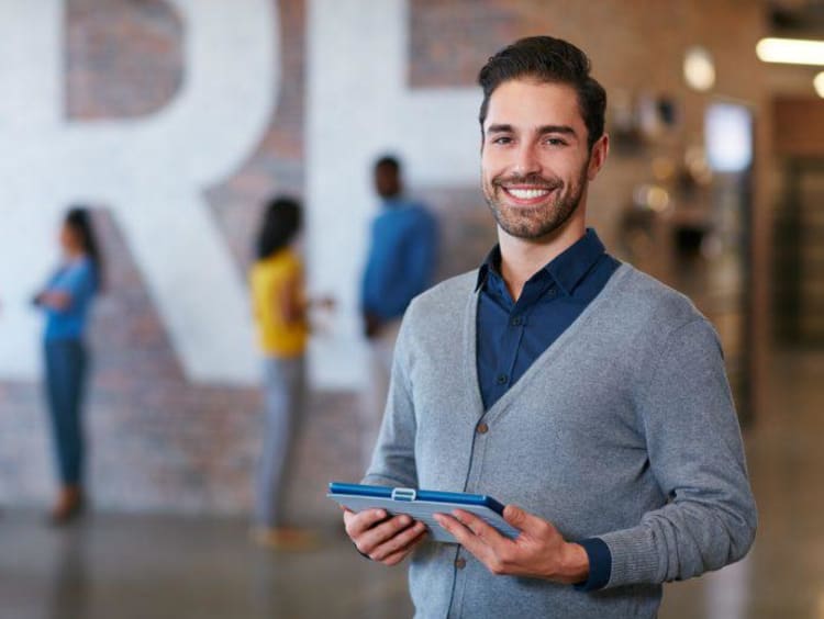 A professionally-dressed man holding a binder