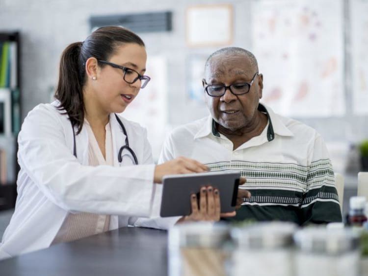 Nurse with older man reading