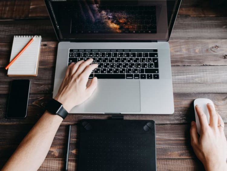 hands typing on a laptop