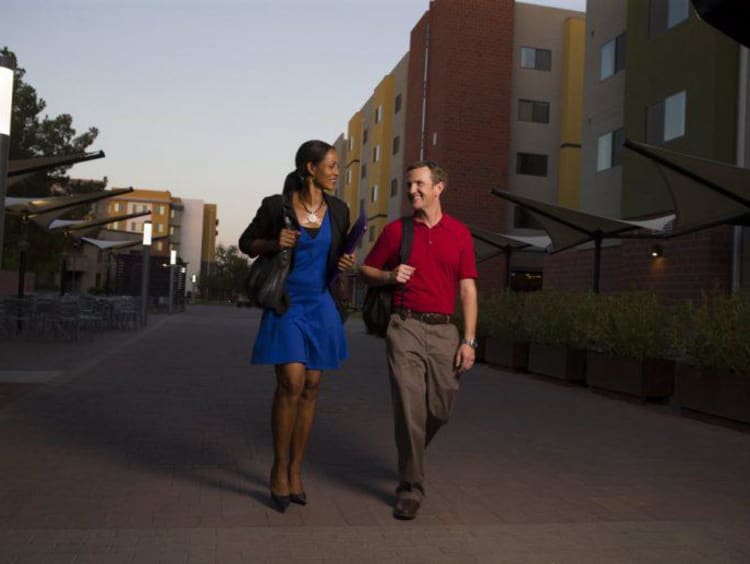 Two adult learners walking down Lopes Way in the evening