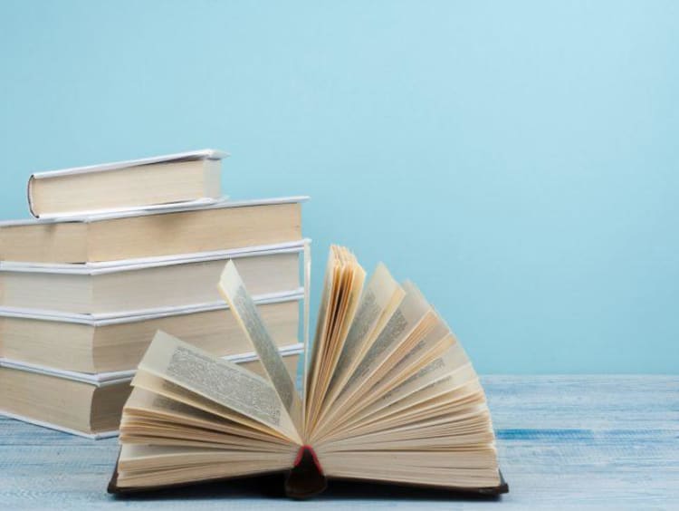 stack of books with one book open 