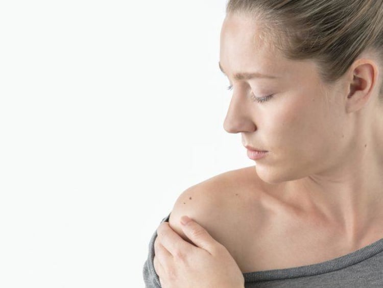 Woman observing her skin for moles