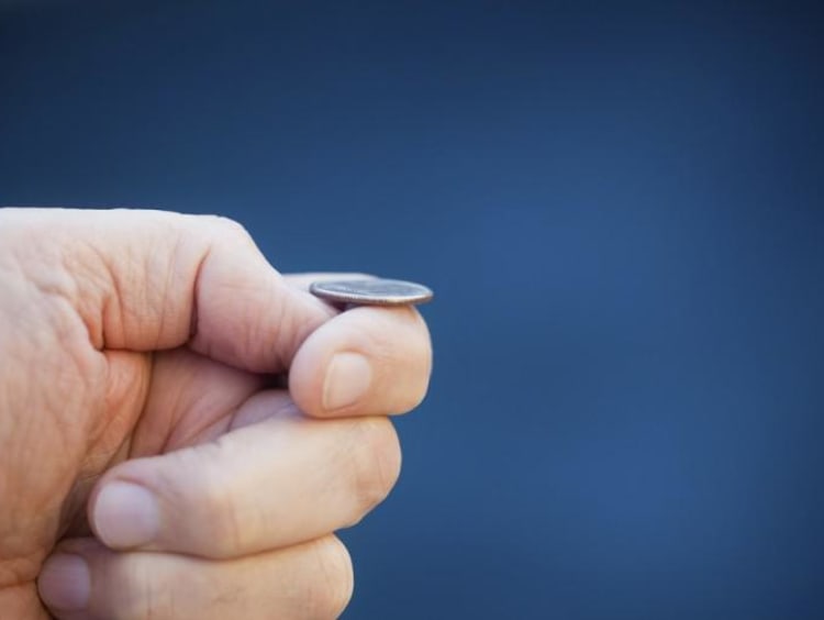 hand balancing a coin