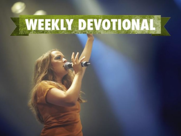 A woman singing under the Weekly Devotional banner