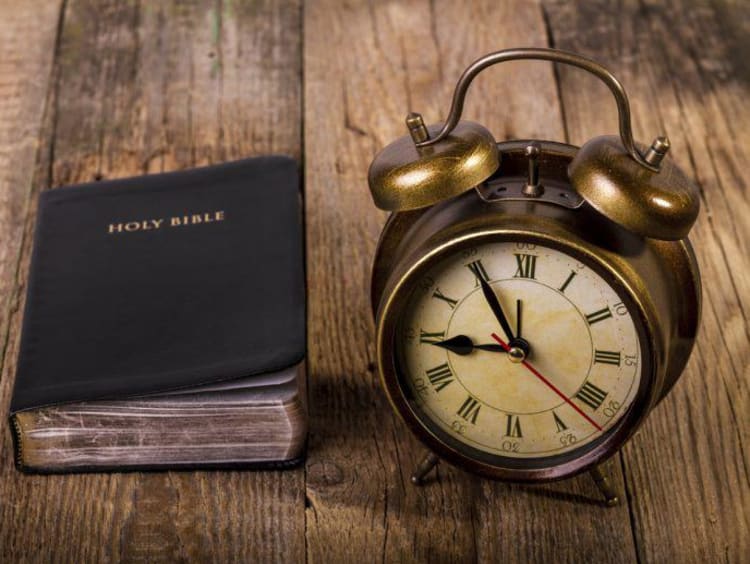 clock and bible on a table