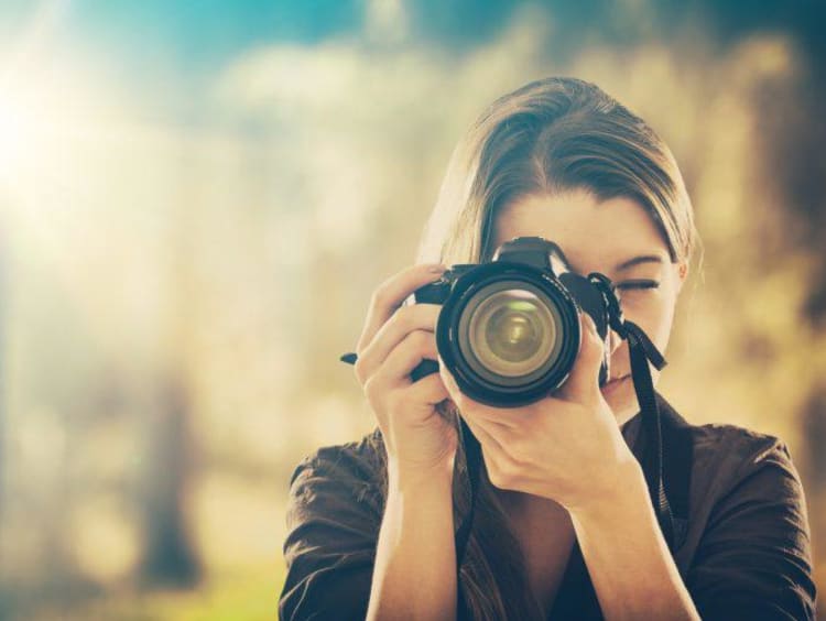 girl holding camera and taking pictures