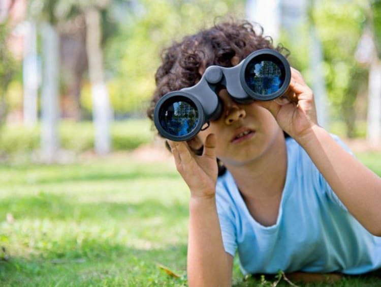 kid looking through binoculars