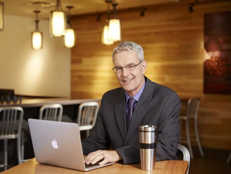 Doctoral student studies in cafe setting on laptop