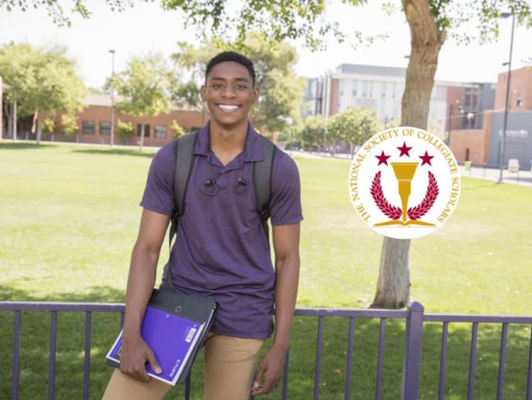 student holding notebook and wearing a backpack smiling