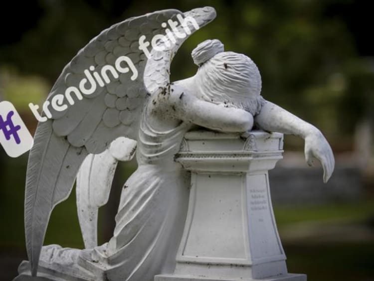 A statue of an angel in mourning under the Trending Faith logo