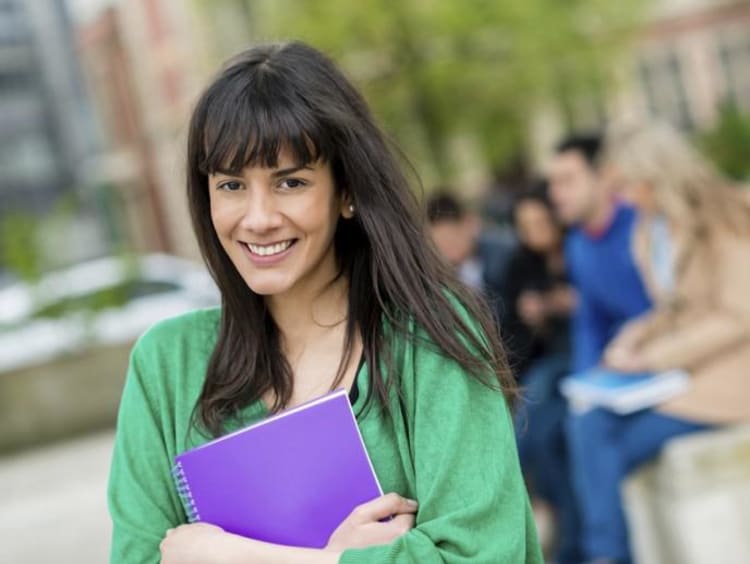 girl holding notebook while walking