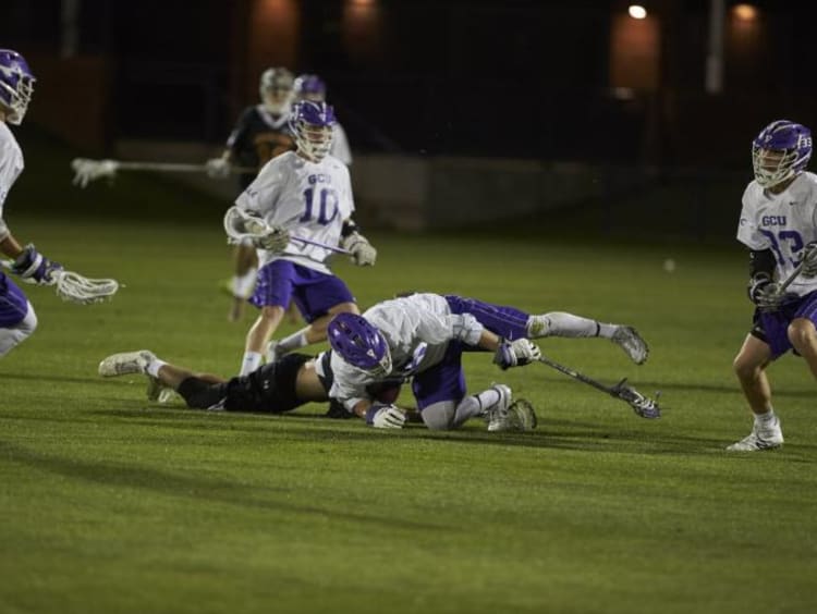 GCU lacrosse players in mid-play on the field