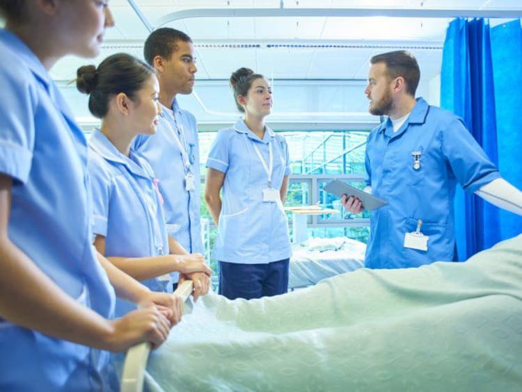 Nursing students by bedside 