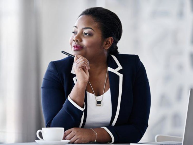 Confident African-American female looks out window daydreaming