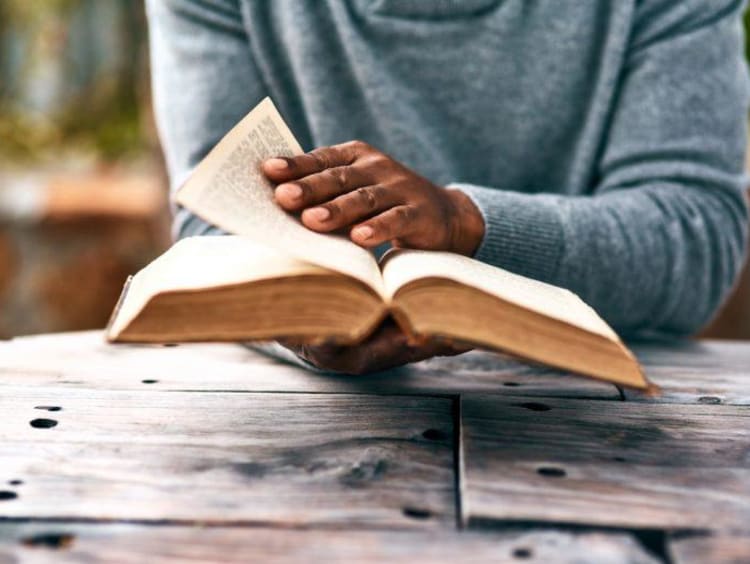 man reading a bible outside