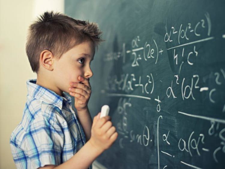 Young student looking at a math problem on a chalkboard