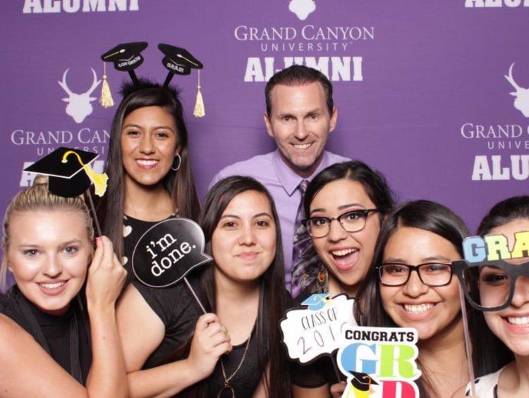 Jim Mostofo poses with recent Education graduates in GCU alumni photo booth