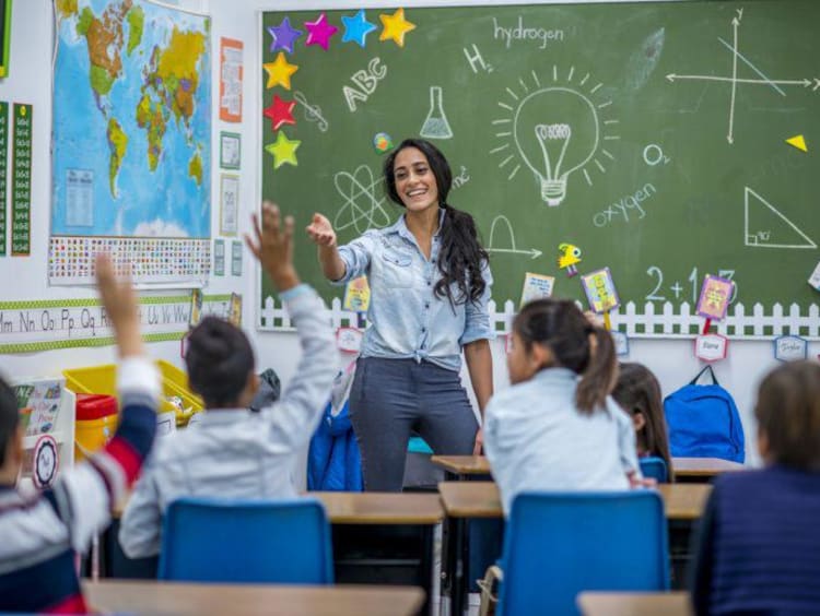 teacher smiling while teaching her students