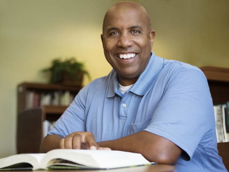 Adult man reads book at table