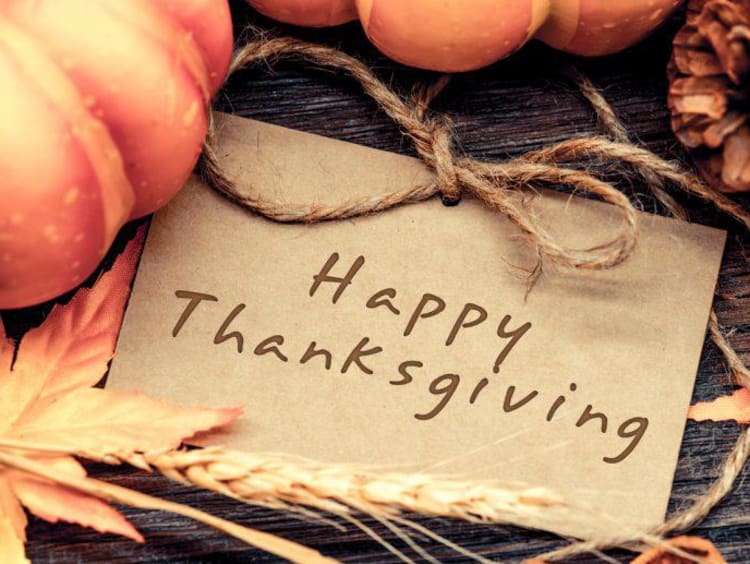 A "Happy Thanksgiving" sign with fall leaves and pumpkins