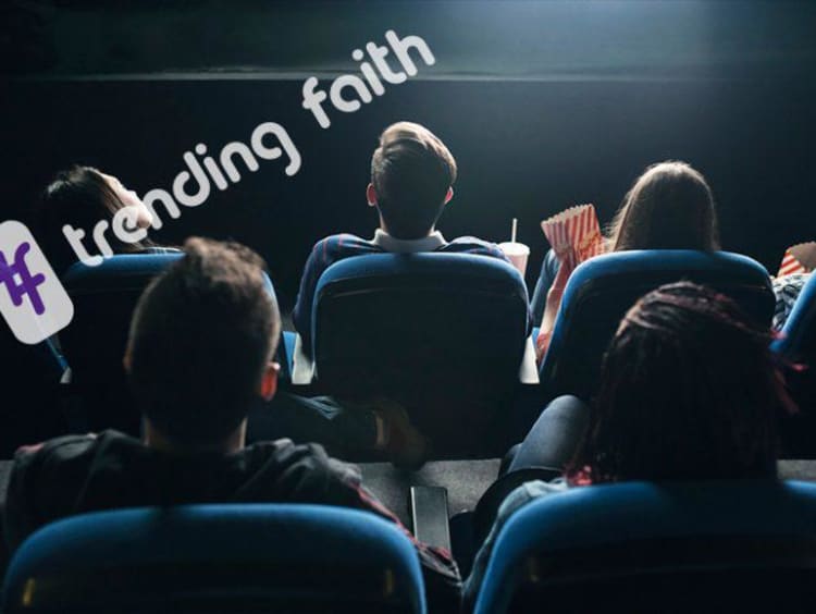 Back view of people seated in a movie theater looking at the front screen