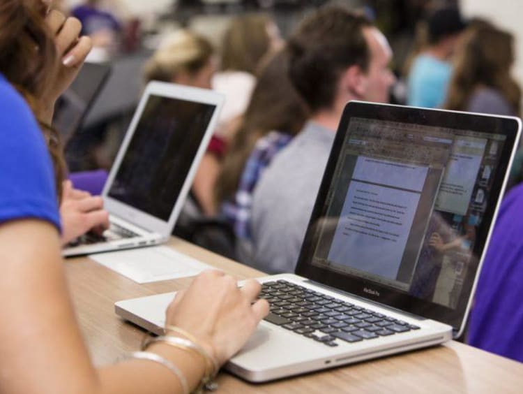 A student writing on her laptop