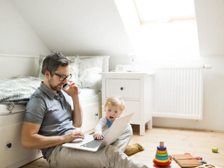 Father spending time with his son while working on a laptop