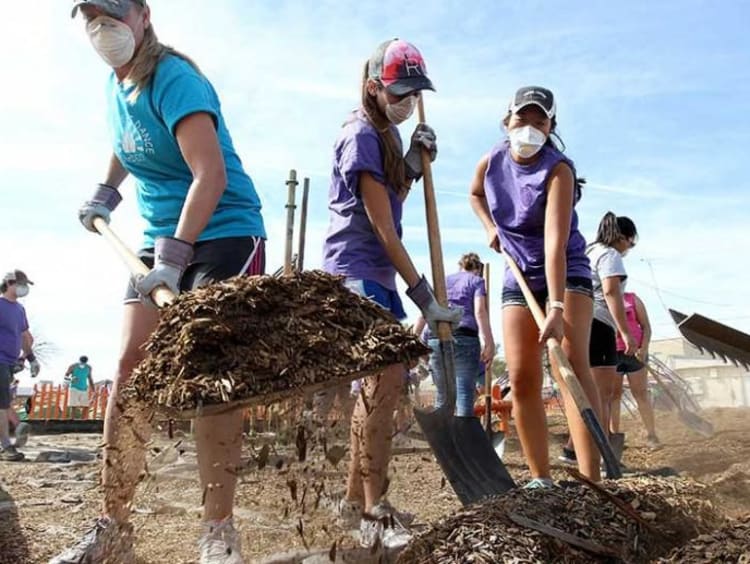 Group of people shoveling at community service