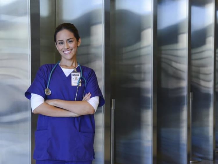 nurse leaning against wall with arms crossed