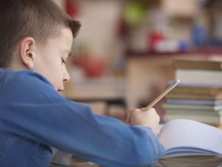 kid writing in notebook