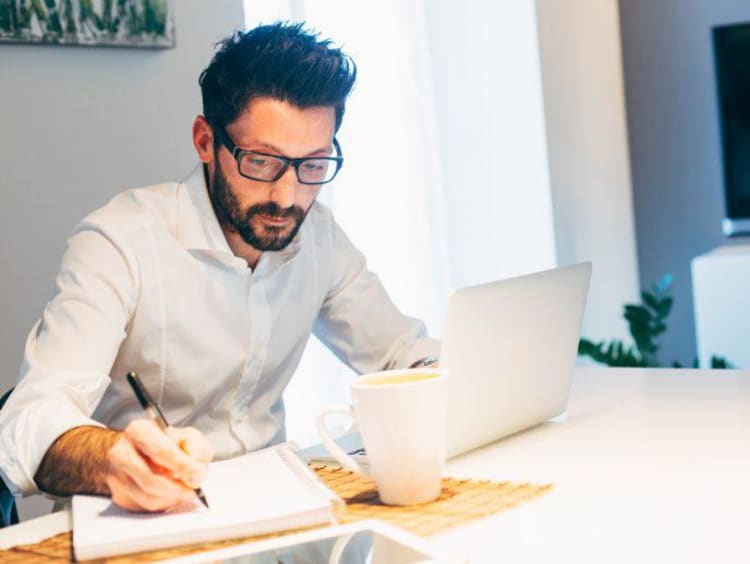 Man with glasses working on laptop