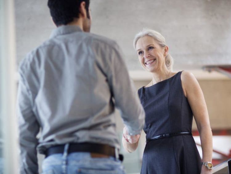 Man and woman greeting each other during an interview