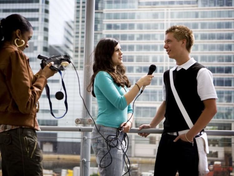 a girl interviewing a guy with camera and mic