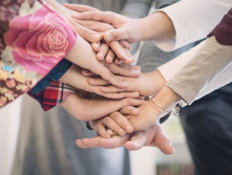 Coworkers piling their hands collaboratively