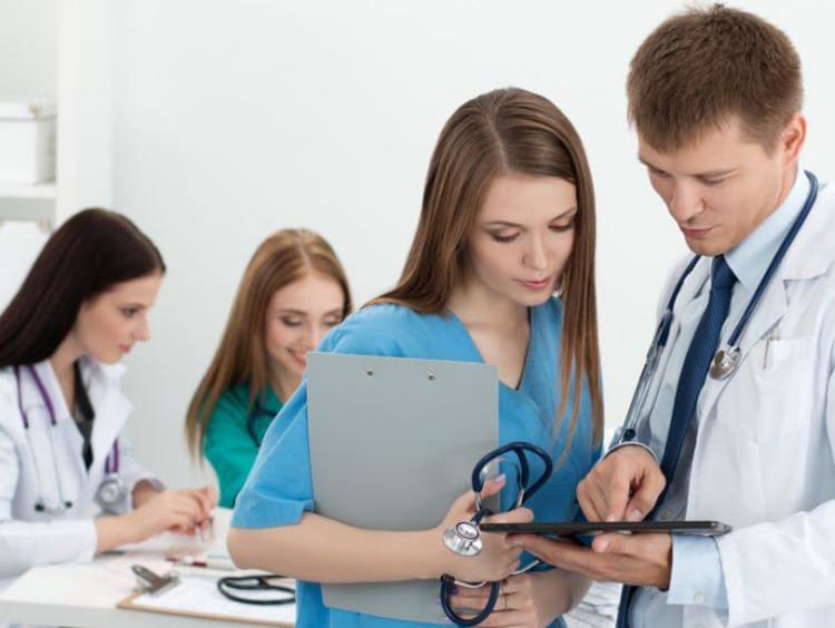 Nurse looking at a screen in doctor's hands