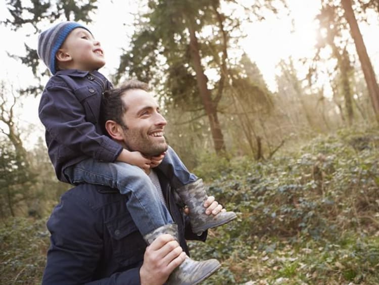 dad carrying son on his shoulders