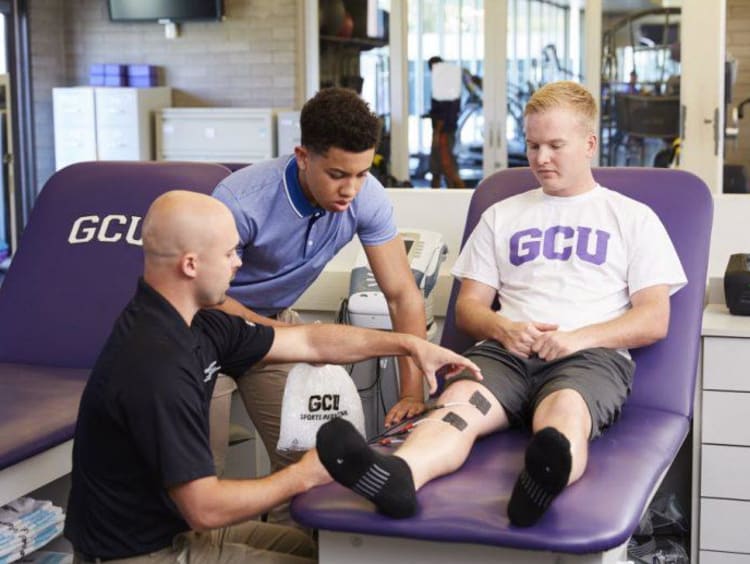 GCU student in the sports medicine room with a technician