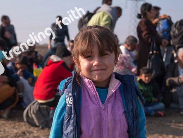 A group of refugees and a young girl with the trending faith logo