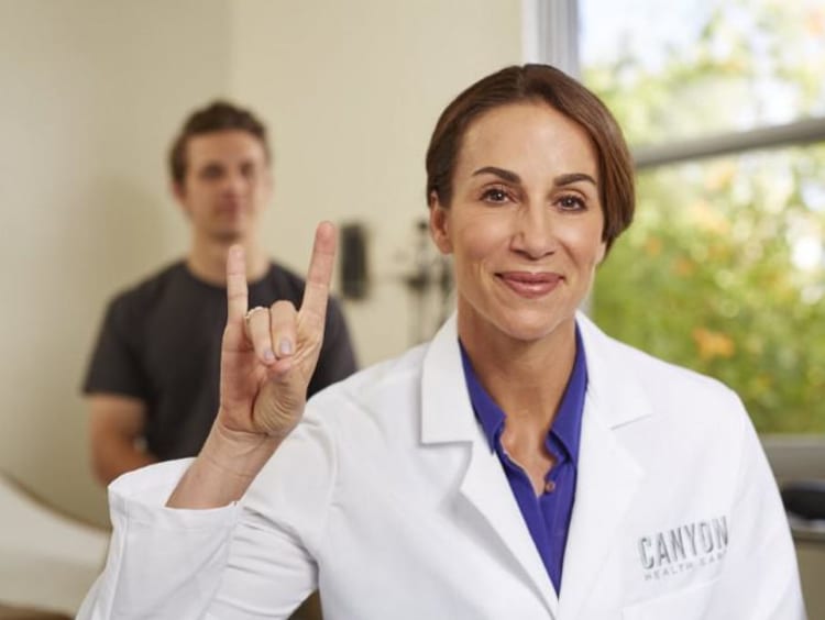 GCU nurse holding her hand in a lopes up