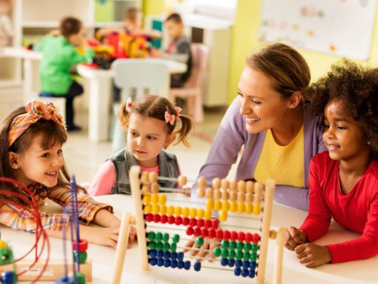 children playing in a classroom with an adult