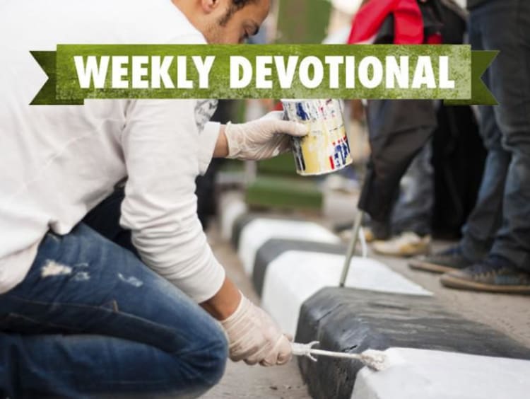 A man painting curbs under the Weekly Devotional banner