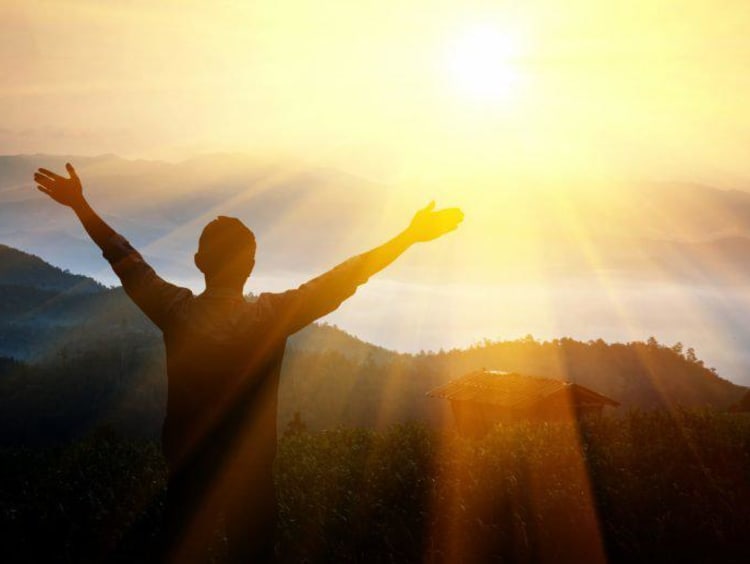 person holding arms out in the sun