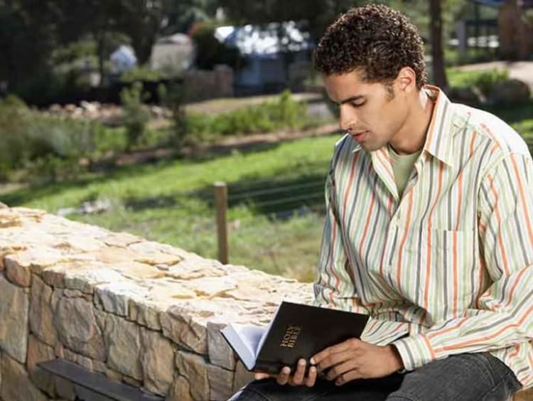 Man sitting while reading the Bible