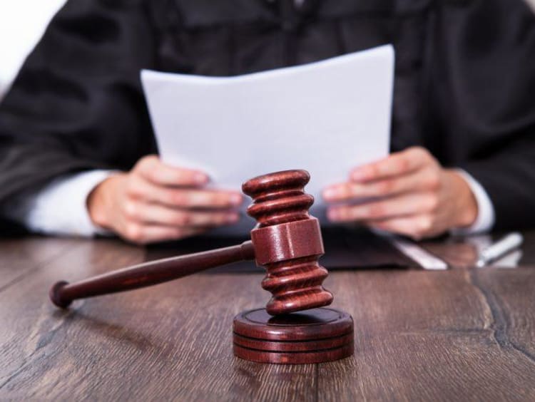 a judge looking at papers with a gavel in front of him